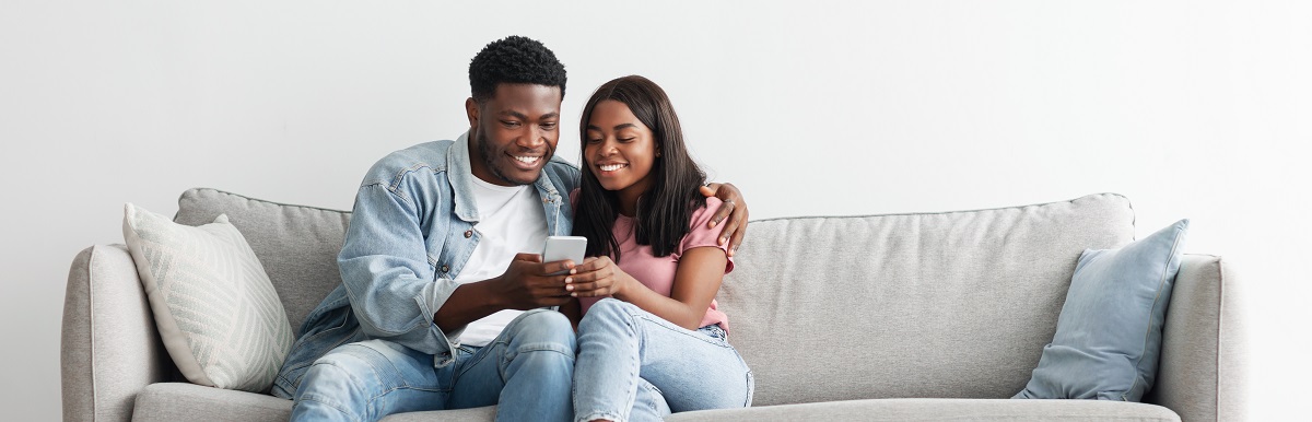 couple on couch with smartphone